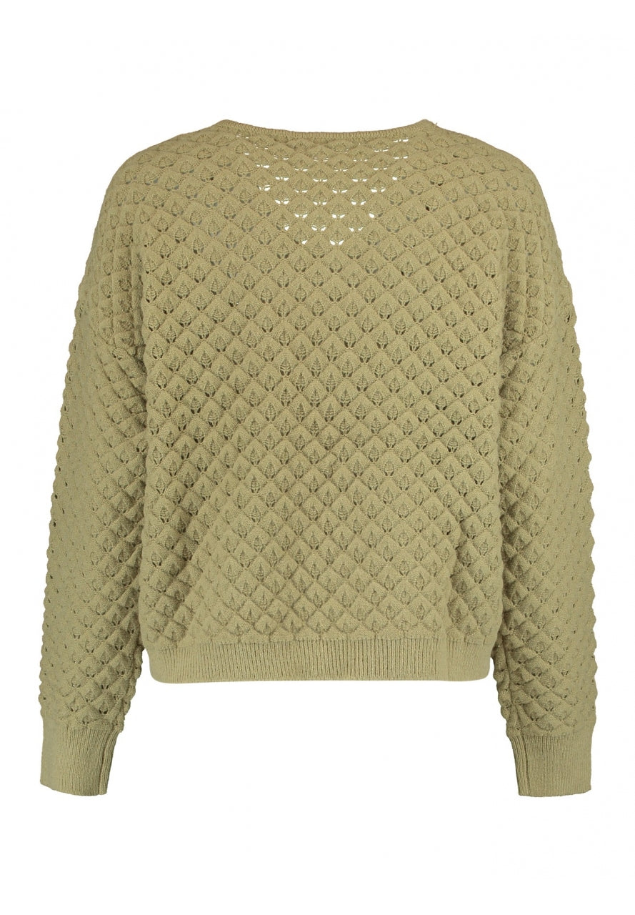 Jersey con dibujo calada y ajustable en cintura para poder acortarlo al gusto. Composición: 43% Poliacrílico, 29% Poliéster y 28% Poliamida. Se recomienda lavar a mano o en lavadora hasta 30º. No usar lejía, planchar suavemente del revés hasta 110º y no usar secadora.