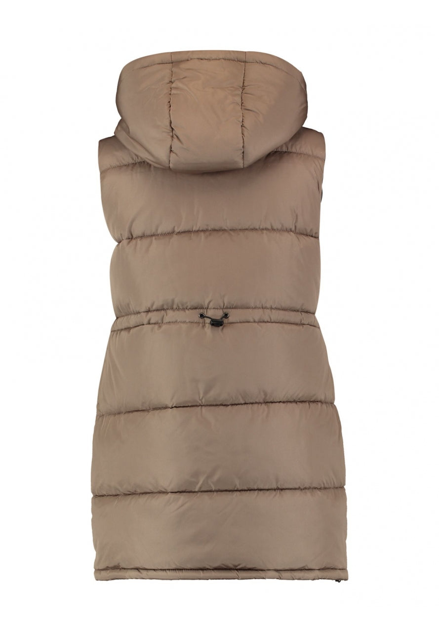 Chaleco largo hasta la cadera, con capucha, bolsillos con cremallera y forrito polar en su  interior. Tiene una goma a la altura de la cintura para ajustarlo en la espalda.
Composición: 100% Poliéster.
Se recomienda lavar a mano o en lavadora hasta 30º. No usar lejía, planchar suavemente del revés hasta 110º y no usar secadora.