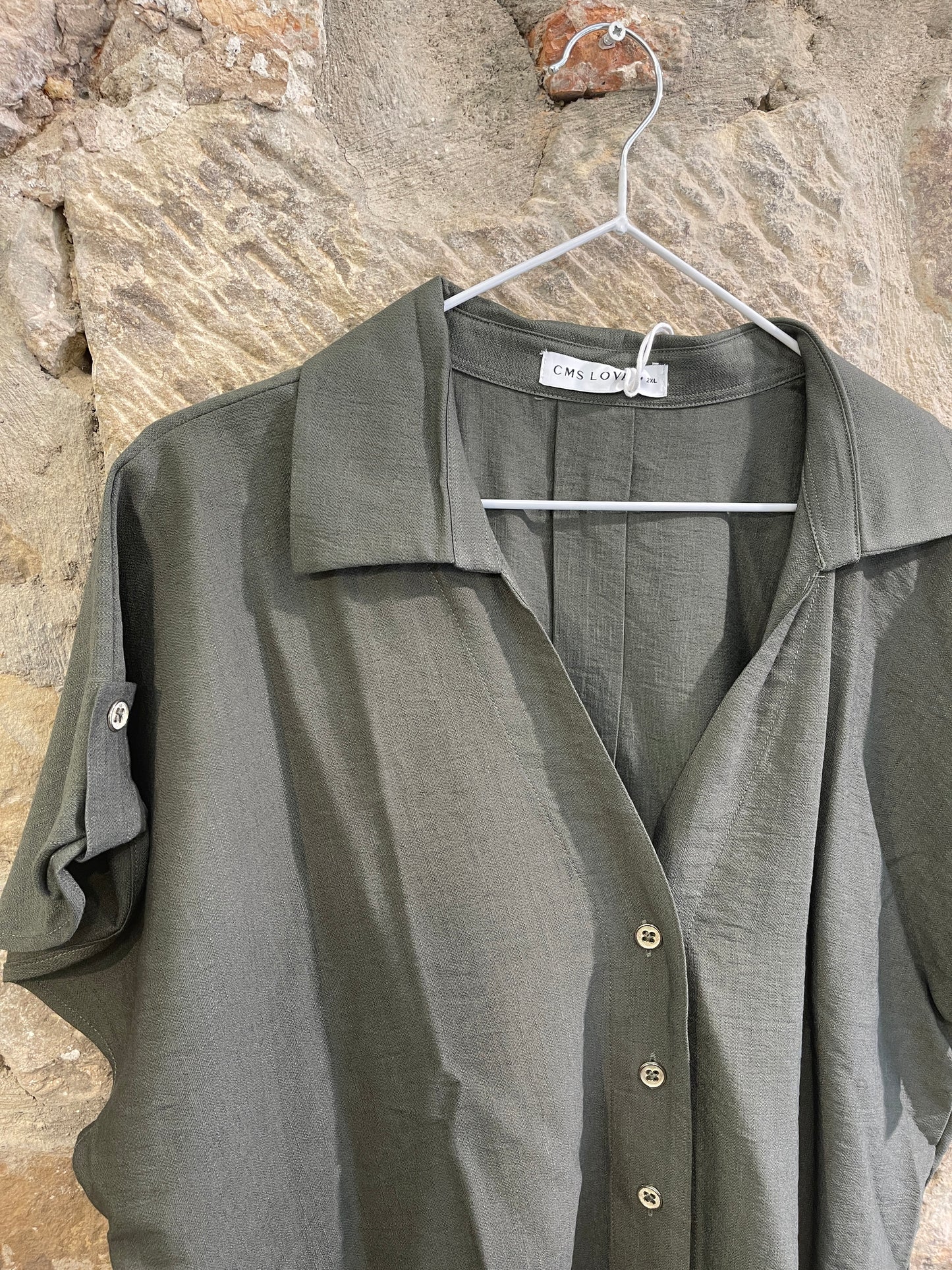 Blusa de manga corta, con cuello y botones. Composición: 100% Poliéster. Se recomienda lavar a mano o en lavadora hasta 30º. No usar lejía, planchar suavemente del revés hasta 110º y no usar secadora.