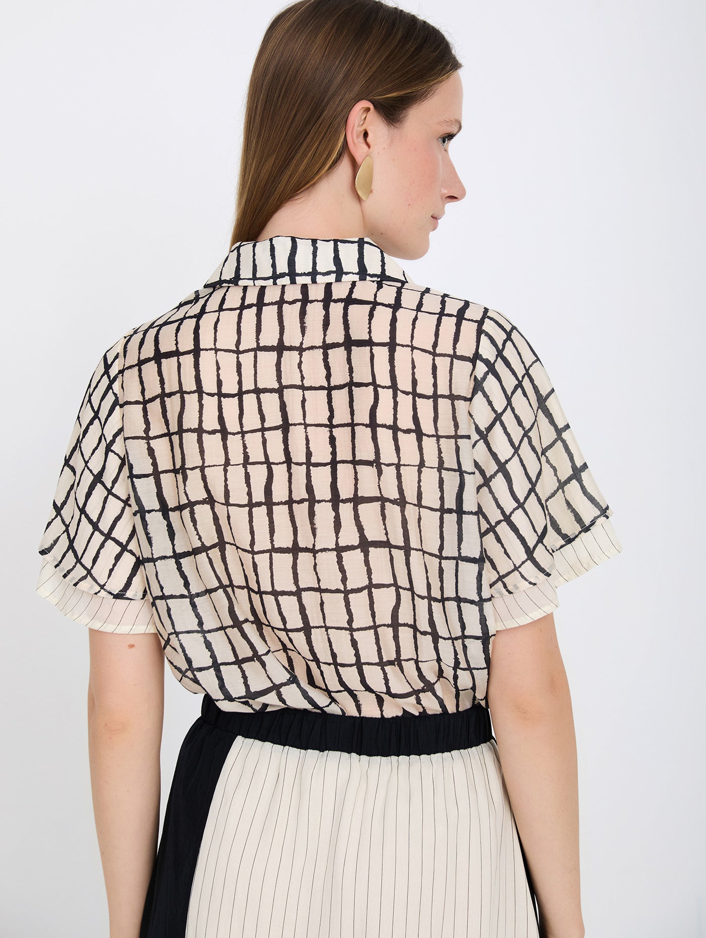 Camisa con tejido fluido de tencel con estampado de cuadros. Cuello solapa y cierre frontal con botones. Manga corta con doble capa de tejido.
Composición: 80% Tencel y 20% Nylon.
Se recomienda lavar a mano o en lavadora hasta 30º. No usar lejía, planchar suavemente del revés hasta 110º y no usar secadora.