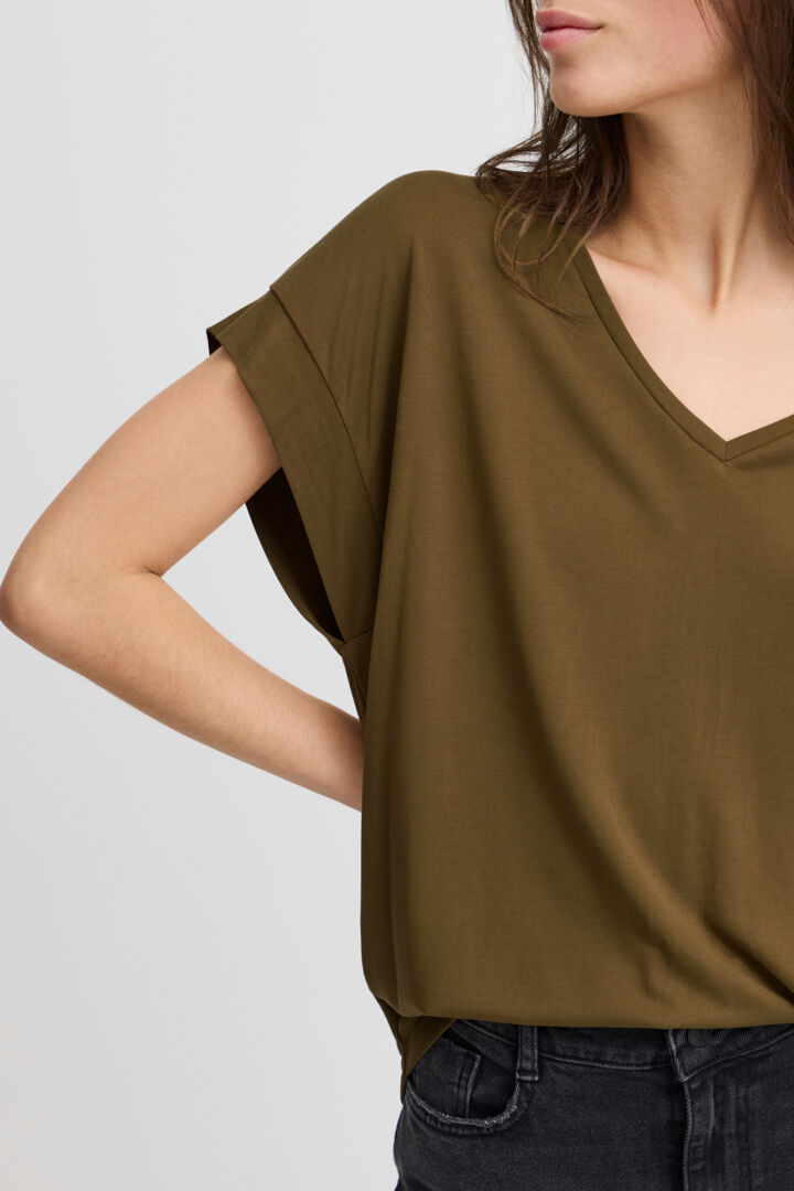 Camiseta de tejido con tacto brutal en color verde militar y detalle de costura en hombros.  Composición: 64% Modal y 36% Poliéster.  Se recomienda lavar a mano o en lavadora hasta 30º. No usar lejía, planchar suavemente del revés hasta 110º y no usar secadora.