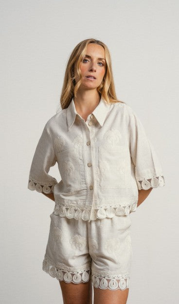 Camisa de corte clásico en tejido ligero con bordados y apliques calados. Cierre frontal con botones decorativos y bolsillos de parche. Ideal para utilizarlo como chaqueta.

Composición: 70% Viscosa y 30% Lino.

Se recomienda lavar a mano o en lavadora hasta 30º. No usar lejía, planchar suavemente del revés hasta 110º y no usar secadora.