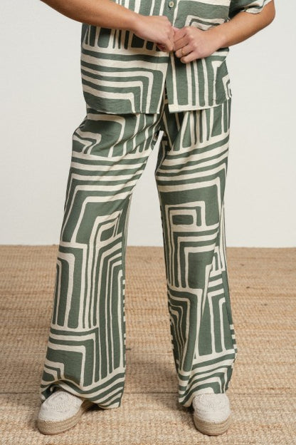 Pantalones fluidos de tejido ligero con estampado geométrico en contraste. cintura de tiro medio y corte relajado.