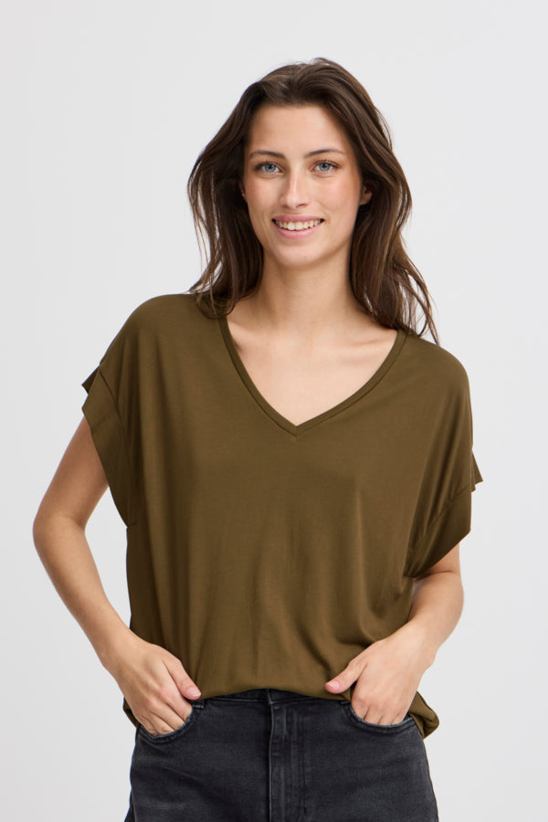 Camiseta de tejido con tacto brutal en color verde militar y detalle de costura en hombros.  Composición: 64% Modal y 36% Poliéster.  Se recomienda lavar a mano o en lavadora hasta 30º. No usar lejía, planchar suavemente del revés hasta 110º y no usar secadora.