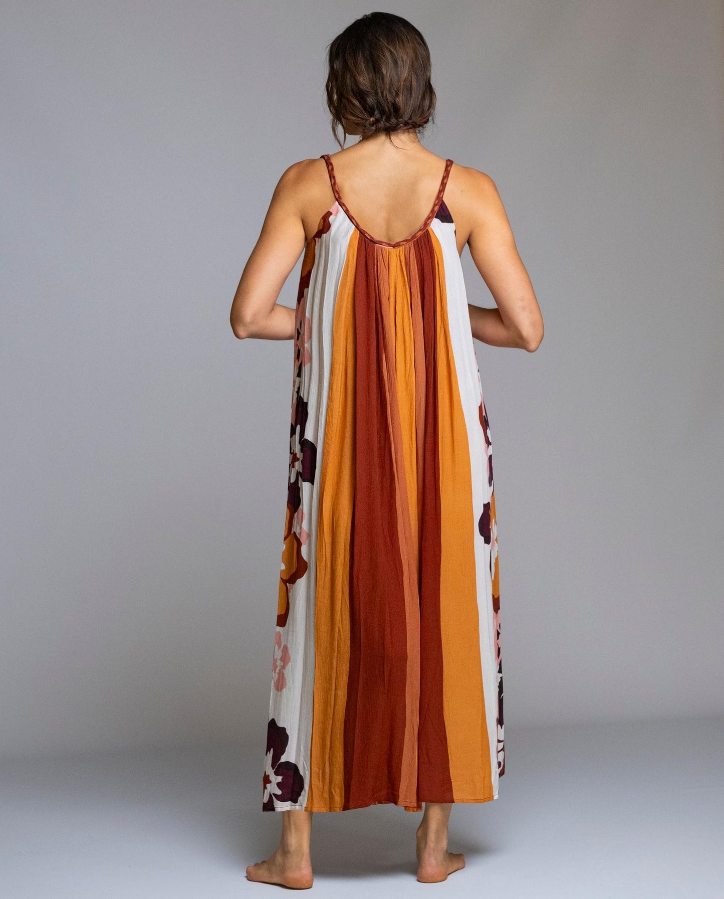 Vestido largo Señoretta confeccionado en viscosa 100%, ligero, fluido y muy agradable al tacto. Diseño sin mangas con tirantes finos y escote redondeado, que aporta frescura y feminidad. Su corte amplio y caída suelta realza el movimiento del tejido y garantiza máxima comodidad. El estampado floral combinado con franjas verticales estiliza la silueta y añade un toque sofisticado y veraniego. Ideal para días cálidos, vacaciones o looks relajados con estilo.

Composición: 100% Viscosa.

Se recomienda lavar a 