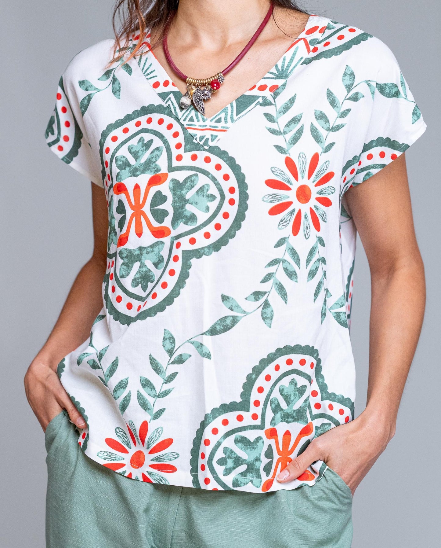 Camiseta de mujer estampada con diseño geométrico y floral en tonos verde y coral, perfecta para un look fresco y actual. Con cuello pico y manga corta caída, ofrece un ajuste cómodo y favorecedor que estiliza la silueta. Su tejido ligero y suave la convierte en una prenda ideal para primavera y verano, fácil de combinar con pantalones lisos, shorts o faldas. Una camiseta versátil y femenina que aporta color y personalidad a tus outfits diarios. Ideal para looks casual y urbanos.

Composición: 100% Viscosa.