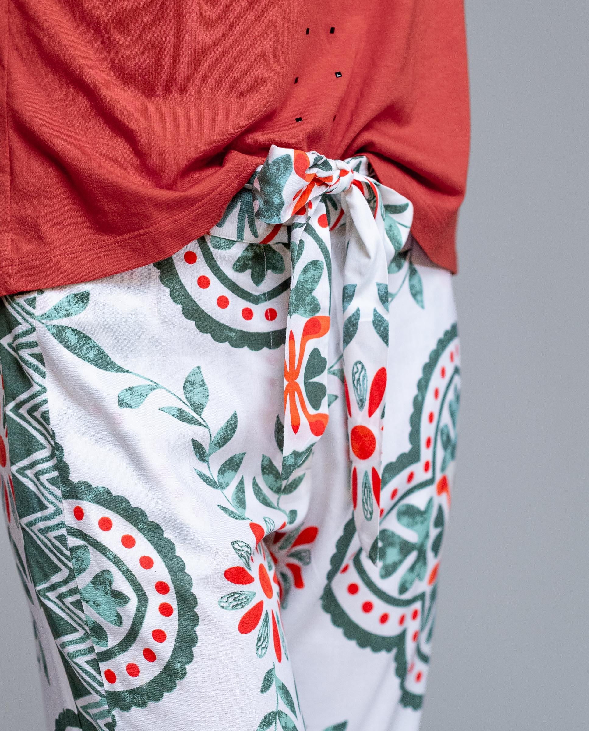 Pantalón estampado de mujer de la marca Señoretta Street, una prenda fresca y actual que combina comodidad y estilo. Con cintura elástica y lazada ajustable, ofrece un ajuste cómodo y favorecedor. Su tejido ligero y fluido aporta movimiento, mientras que el estampado floral y geométrico en tonos verdes y rojos sobre fondo claro añade un toque original y veraniego. Perfecto para crear looks desenfadados con sandalias o combinar con su camiseta a juego para un conjunto coordinado.

Composición: 100% Viscosa.
