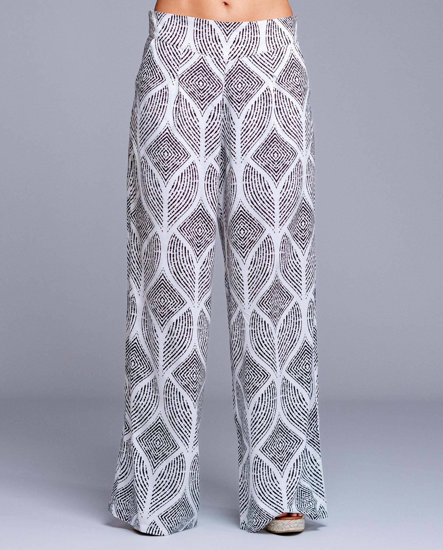 Pantalón de mujer estampado geométrico de corte amplio estilo fluido y elegante. Diseño de pierna ancha con caída ligera que estiliza la silueta y aporta comodidad durante todo el día. Cintura cómoda que se adapta perfectamente al cuerpo, ideal para looks urbanos, outfits de verano o combinaciones más sofisticadas. Perfecto para combinar con blusas lisas o tops ajustados y crear un conjunto moderno y femenino.

Composición: 100% Viscosa.

Se recomienda lavar a mano o en lavadora hasta 30º. No usar lejía, pl