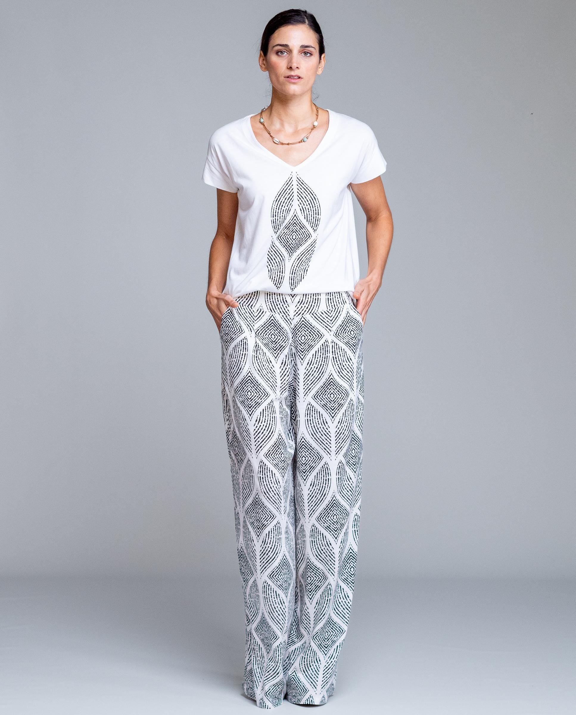 Pantalón de mujer estampado geométrico de corte amplio estilo fluido y elegante. Diseño de pierna ancha con caída ligera que estiliza la silueta y aporta comodidad durante todo el día. Cintura cómoda que se adapta perfectamente al cuerpo, ideal para looks urbanos, outfits de verano o combinaciones más sofisticadas. Perfecto para combinar con blusas lisas o tops ajustados y crear un conjunto moderno y femenino.

Composición: 100% Viscosa.

Se recomienda lavar a mano o en lavadora hasta 30º. No usar lejía, pl