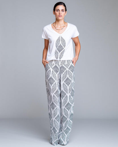 Pantalón de mujer estampado geométrico de corte amplio estilo fluido y elegante. Diseño de pierna ancha con caída ligera que estiliza la silueta y aporta comodidad durante todo el día. Cintura cómoda que se adapta perfectamente al cuerpo, ideal para looks urbanos, outfits de verano o combinaciones más sofisticadas. Perfecto para combinar con blusas lisas o tops ajustados y crear un conjunto moderno y femenino.

Composición: 100% Viscosa.

Se recomienda lavar a mano o en lavadora hasta 30º. No usar lejía, pl