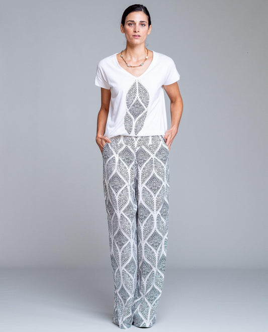 Pantalón de mujer estampado geométrico de corte amplio estilo fluido y elegante. Diseño de pierna ancha con caída ligera que estiliza la silueta y aporta comodidad durante todo el día. Cintura cómoda que se adapta perfectamente al cuerpo, ideal para looks urbanos, outfits de verano o combinaciones más sofisticadas. Perfecto para combinar con blusas lisas o tops ajustados y crear un conjunto moderno y femenino.

Composición: 100% Viscosa.

Se recomienda lavar a mano o en lavadora hasta 30º. No usar lejía, pl