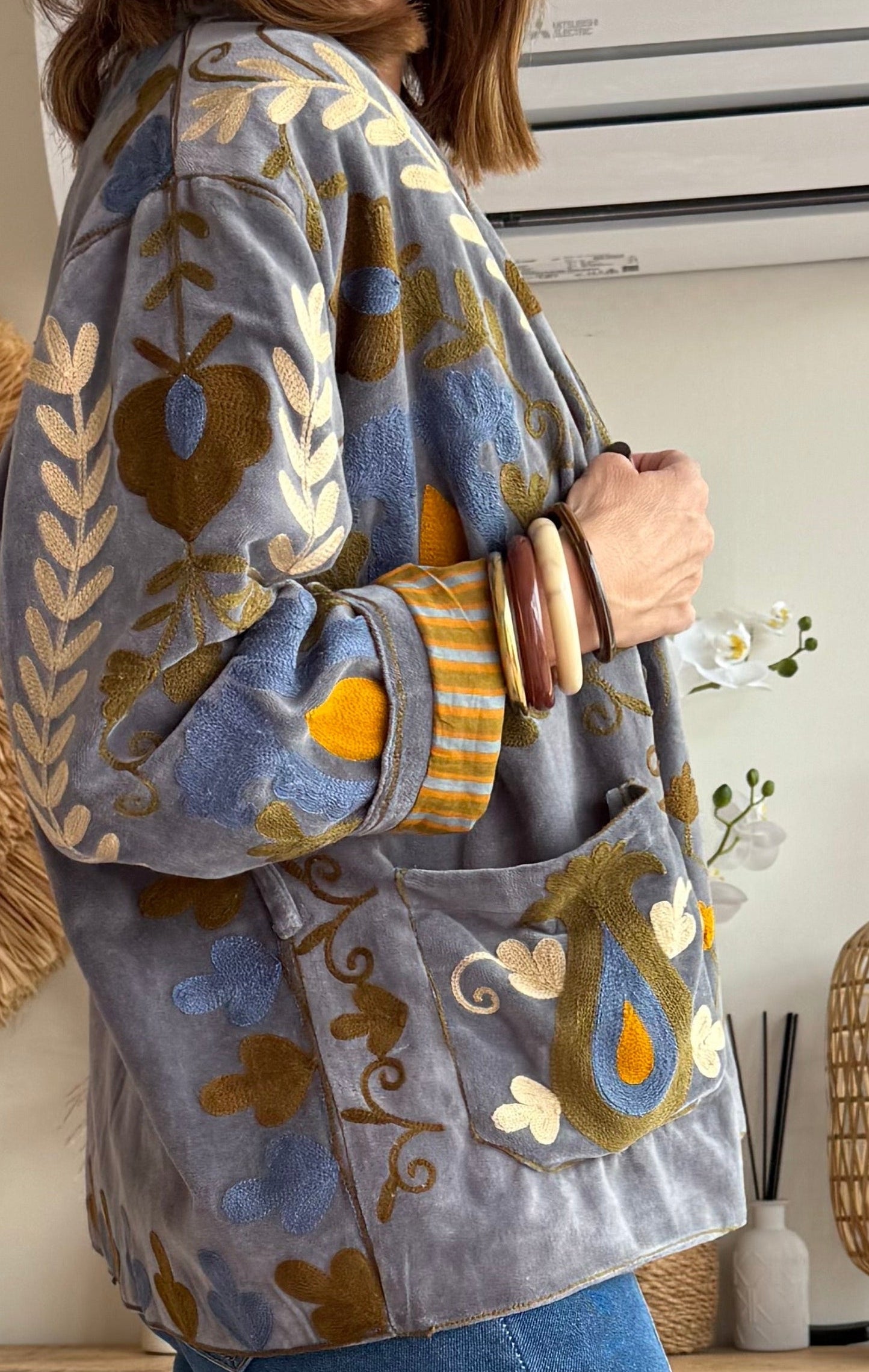 Chaqueta tipo kimono de terciopelo en tono gris con preciosos bordados florales en mostaza, azul y crema.

Cada pieza está bordada artesanalmente, lo que la convierte en una prenda&nbsp;

Perfecta para elevar cualquier look con ese aire boho y sofisticado que tanto nos gusta.

Composición: 100% Algodón.

Se recomienda lavar a mano o en lavadora hasta 30º. No usar lejía, planchar suavemente del revés hasta 110º y no usar secadora.