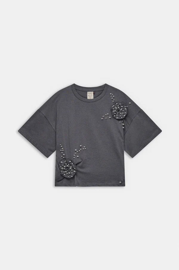 Camiseta de manga corta en tono beige con original aplicación floral en relieve y pequeños detalles decorativos. Su diseño combina sencillez y un toque artesanal que aporta personalidad. El tejido de algodón ofrece suavidad y comodidad para el día a día. Una prenda especial que añade un aire delicado y creativo a cualquier look.

Composición: !00% Algodón.

Se recomienda lavar a mano o en lavadora hasta 30º. No usar lejía, planchar suavemente del revés hasta 110º y no usar secadora.