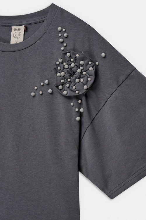 Camiseta de manga corta en tono beige con original aplicación floral en relieve y pequeños detalles decorativos. Su diseño combina sencillez y un toque artesanal que aporta personalidad. El tejido de algodón ofrece suavidad y comodidad para el día a día. Una prenda especial que añade un aire delicado y creativo a cualquier look.

Composición: !00% Algodón.

Se recomienda lavar a mano o en lavadora hasta 30º. No usar lejía, planchar suavemente del revés hasta 110º y no usar secadora.