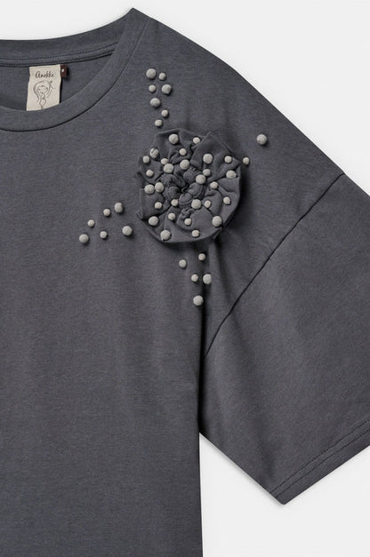 Camiseta de manga corta en tono beige con original aplicación floral en relieve y pequeños detalles decorativos. Su diseño combina sencillez y un toque artesanal que aporta personalidad. El tejido de algodón ofrece suavidad y comodidad para el día a día. Una prenda especial que añade un aire delicado y creativo a cualquier look.

Composición: !00% Algodón.

Se recomienda lavar a mano o en lavadora hasta 30º. No usar lejía, planchar suavemente del revés hasta 110º y no usar secadora.