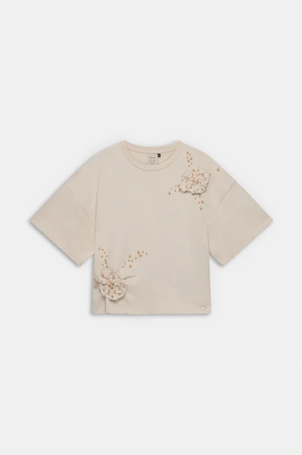 Camiseta de manga corta en tono beige con original aplicación floral en relieve y pequeños detalles decorativos. Su diseño combina sencillez y un toque artesanal que aporta personalidad. El tejido de algodón ofrece suavidad y comodidad para el día a día. Una prenda especial que añade un aire delicado y creativo a cualquier look.

Composición: !00% Algodón.

Se recomienda lavar a mano o en lavadora hasta 30º. No usar lejía, planchar suavemente del revés hasta 110º y no usar secadora.
