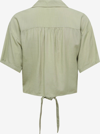 Camisa de manga corta y cuello de solapa, con lazo en cintura.

Composición: 90% Viscosa y 10% Lino.

Se recomienda lavar a mano o en lavadora hasta 30º. No usar lejía, planchar suavemente del revés hasta 110º y no usar secadora.