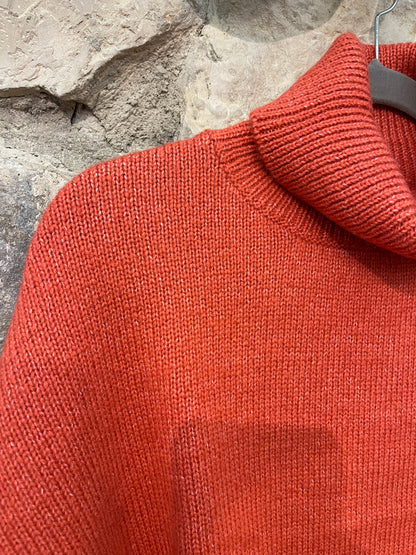 Jersey de punto de cuello alto, detalle de costura en brazos, acabado en puño y corte ancho.

Composición:&nbsp;66% acrílico, 27% poliéster y 7% lana.

Se recomienda lavar a mano o en lavadora hasta 30º. No usar lejía, planchar suavemente del revés hasta 110º y no usar secadora.