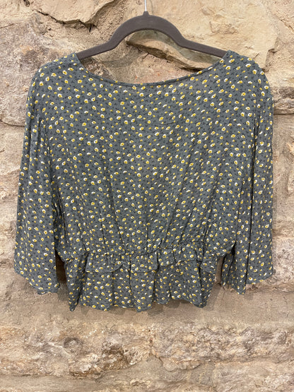 Blusa floral con detalle de volante bajo el pecho.  Composición: 100% Viscosa.  *Los artículos con descuentos o de la zona outlet NO ADMITEN DEVOLUCIONES Y LOS CAMBIOS ESTARÁN SUJETOS DISPONIBILIDAD DEL PRODUCTO.&nbsp;  Se recomienda lavar a mano o en lavadora hasta 30º. No usar lejía, planchar suavemente del revés hasta 110º y no usar secadora.