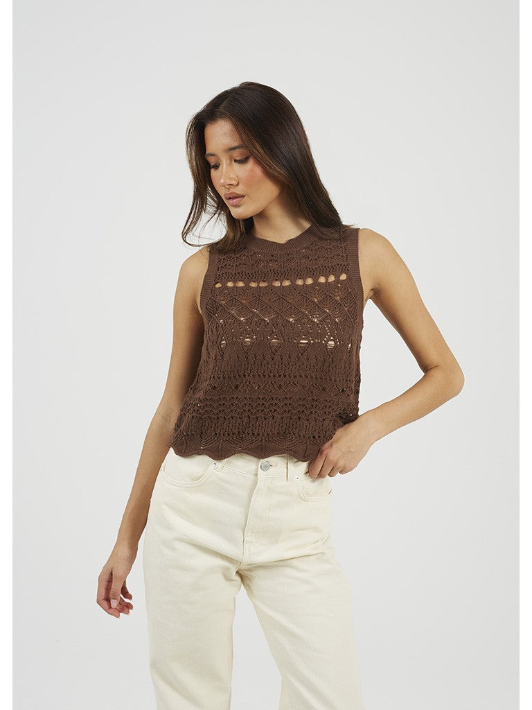 Top de punto para mujer sin mangas y cuello caja. Punto calado y detalle de volante en bajo. Botones decorativos muy originales y estilosos.

Composición: 100% Algodón.

Se recomienda lavar a mano o en lavadora hasta 30º. No usar lejía, planchar suavemente del revés hasta 110º y no usar secadora.