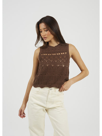 Top de punto para mujer sin mangas y cuello caja. Punto calado y detalle de volante en bajo. Botones decorativos muy originales y estilosos.

Composición: 100% Algodón.

Se recomienda lavar a mano o en lavadora hasta 30º. No usar lejía, planchar suavemente del revés hasta 110º y no usar secadora.
