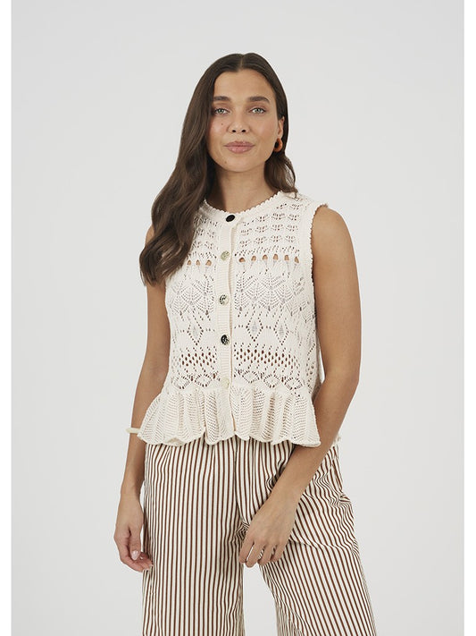 Top de punto para mujer sin mangas y cuello caja. Punto calado y detalle de volante en bajo. Botones decorativos muy originales y estilosos.

Composición: 100% Algodón.

Se recomienda lavar a mano o en lavadora hasta 30º. No usar lejía, planchar suavemente del revés hasta 110º y no usar secadora.