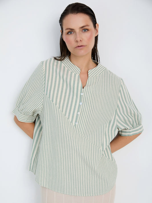 Camisa con tejido rústico a rayas combinadas de diferentes tamaños. Cuello Mao con escote pico y botones. Manga corta abullonada.

Composición: 100% Algodón.

Se recomienda lavar a mano o en lavadora hasta 30º. No usar lejía, planchar suavemente del revés hasta 110º y no usar secadora.