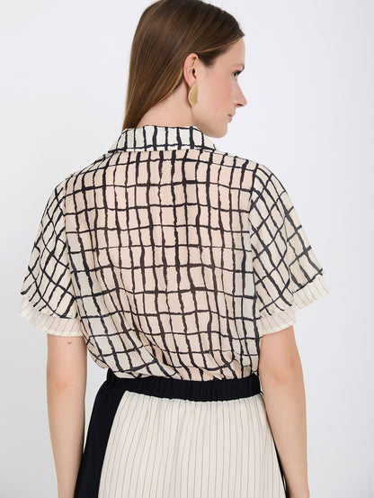 Camisa con tejido fluido de tencel con estampado de cuadros. Cuello solapa y cierre frontal con botones. Manga corta con doble capa de tejido.

Composición: 80% Tencel y 20% Nylon.

Se recomienda lavar a mano o en lavadora hasta 30º. No usar lejía, planchar suavemente del revés hasta 110º y no usar secadora.