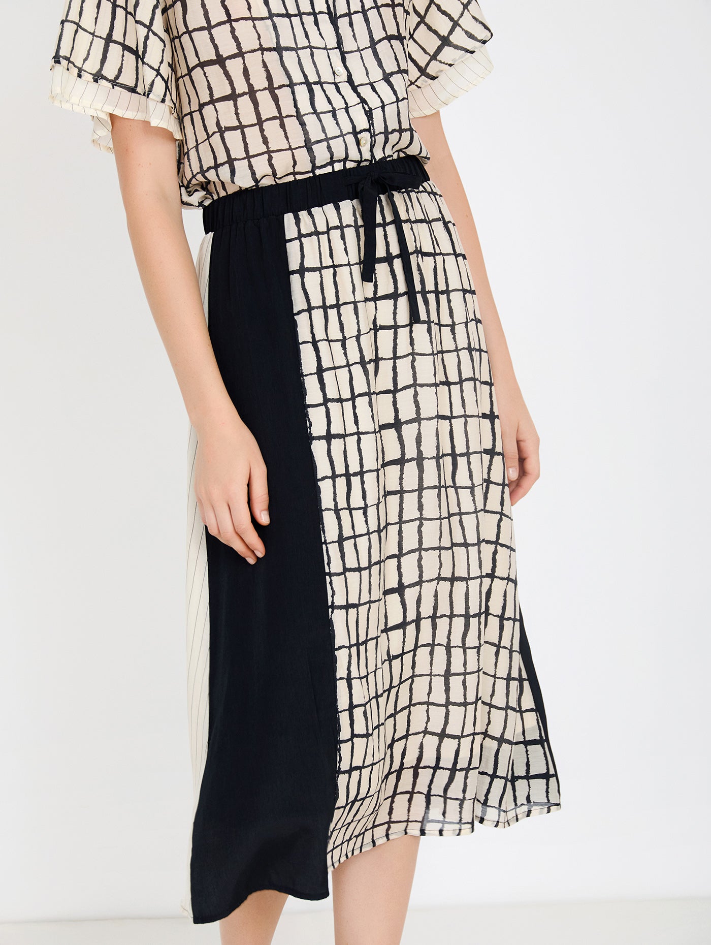 Falda midi en tejido combinado de tencel fluido con diseño tipo patchwork. Combinación de estampados de cuadros y rayas y un tejido liso. Cinturilla elástica y ajustable con lazo. Tiene forro. Dispone de camisa estampada a conjunto, se vende por separado.

Composición: 80% Tencel y 20% Nylon.

Se recomienda lavar a mano o en lavadora hasta 30º. No usar lejía, planchar suavemente del revés hasta 110º y no usar secadora.