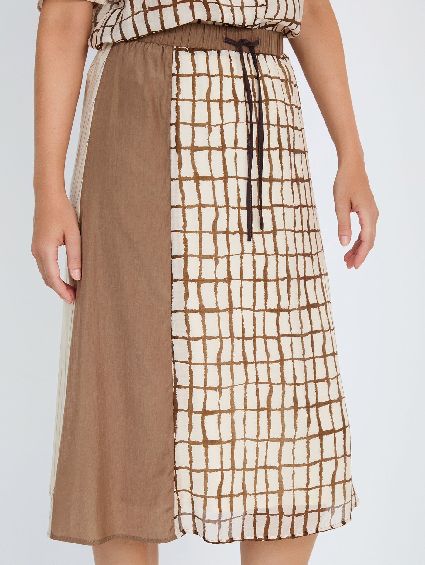 Falda midi en tejido combinado de tencel fluido con diseño tipo patchwork. Combinación de estampados de cuadros y rayas y un tejido liso. Cinturilla elástica y ajustable con lazo. Tiene forro. Dispone de camisa estampada a conjunto, se vende por separado.

Composición: 80% Tencel y 20% Nylon.

Se recomienda lavar a mano o en lavadora hasta 30º. No usar lejía, planchar suavemente del revés hasta 110º y no usar secadora.