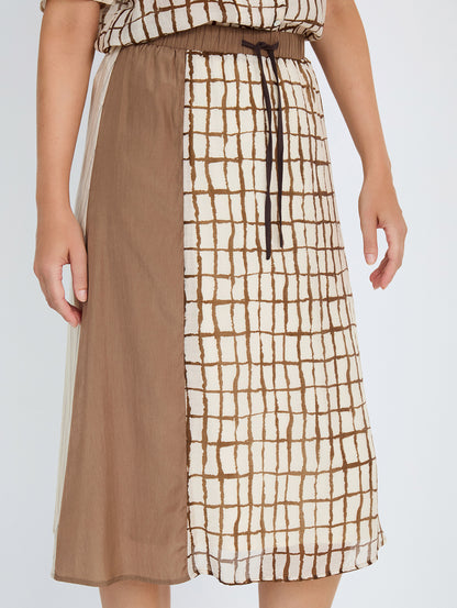 Falda midi en tejido combinado de tencel fluido con diseño tipo patchwork. Combinación de estampados de cuadros y rayas y un tejido liso. Cinturilla elástica y ajustable con lazo. Tiene forro. Dispone de camisa estampada a conjunto, se vende por separado.

Composición: 80% Tencel y 20% Nylon.

Se recomienda lavar a mano o en lavadora hasta 30º. No usar lejía, planchar suavemente del revés hasta 110º y no usar secadora.