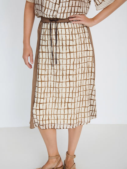 Falda midi en tejido combinado de tencel fluido con diseño tipo patchwork. Combinación de estampados de cuadros y rayas y un tejido liso. Cinturilla elástica y ajustable con lazo. Tiene forro. Dispone de camisa estampada a conjunto, se vende por separado.

Composición: 80% Tencel y 20% Nylon.

Se recomienda lavar a mano o en lavadora hasta 30º. No usar lejía, planchar suavemente del revés hasta 110º y no usar secadora.