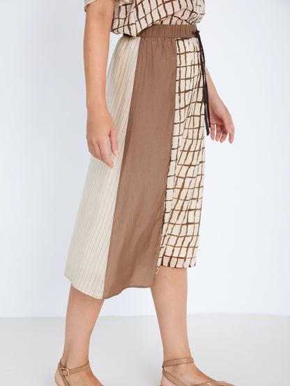 Falda midi en tejido combinado de tencel fluido con diseño tipo patchwork. Combinación de estampados de cuadros y rayas y un tejido liso. Cinturilla elástica y ajustable con lazo. Tiene forro. Dispone de camisa estampada a conjunto, se vende por separado.

Composición: 80% Tencel y 20% Nylon.

Se recomienda lavar a mano o en lavadora hasta 30º. No usar lejía, planchar suavemente del revés hasta 110º y no usar secadora.