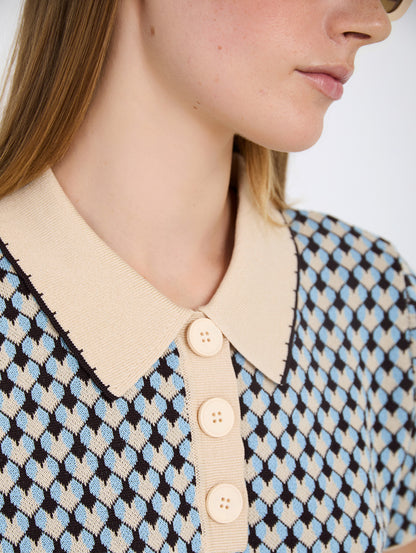 Top de punto con diseño Jacquard geométrico de rombos. Cuello polo a contraste con detalle de pespunte decorativo y cierre de tapeta con botones. Fitting recto. Tiene falda a conjunto, se venden por separado.

Composición: 85% Viscosa y 15% PET.

Se recomienda lavar a mano o en lavadora hasta 30º. No usar lejía, planchar suavemente del revés hasta 110º y no usar secadora.