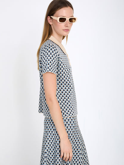 Top de punto con diseño Jacquard geométrico de rombos. Cuello polo a contraste con detalle de pespunte decorativo y cierre de tapeta con botones. Fitting recto. Tiene falda a conjunto, se venden por separado.

Composición: 85% Viscosa y 15% PET.

Se recomienda lavar a mano o en lavadora hasta 30º. No usar lejía, planchar suavemente del revés hasta 110º y no usar secadora.