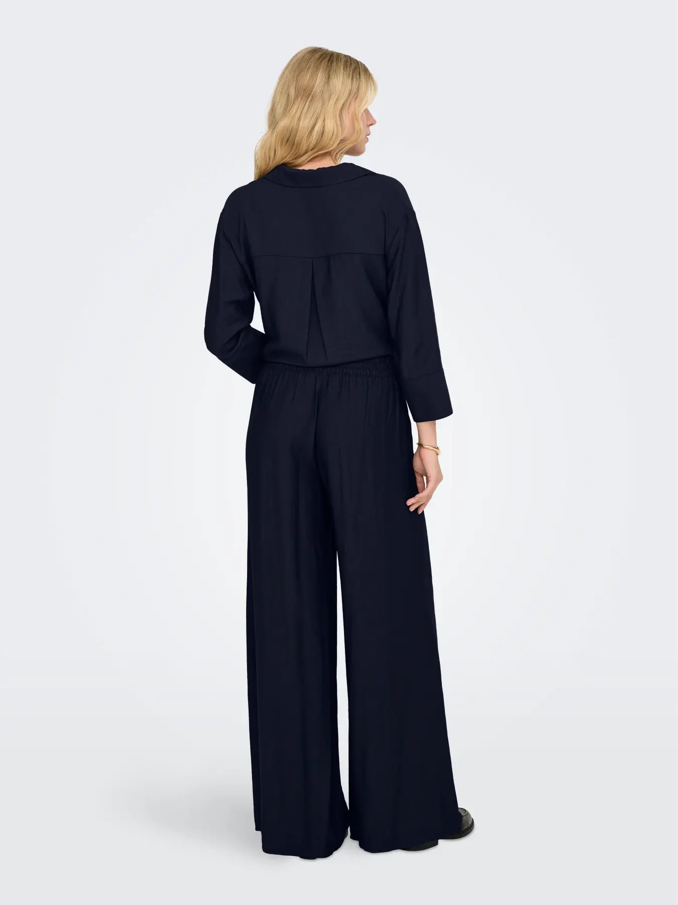 Pantalón ancho de pata, tipo palazzo, tejido fino, con goma en culete y con bolsillos que se adapta tanto a un look trotero, como al mas estiloso del evento.&nbsp;


Composición: 100% Poliéster.


Se recomienda lavar a mano o en lavadora hasta 30º. No usar lejía, planchar suavemente
del revés hasta 110º y no usar secadora.