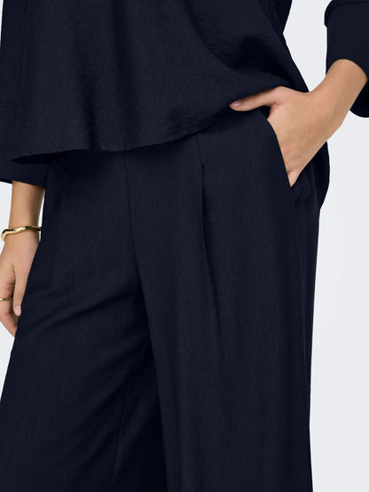 Pantalón ancho de pata, tipo palazzo, tejido fino, con goma en culete y con bolsillos que se adapta tanto a un look trotero, como al mas estiloso del evento.&nbsp;


Composición: 100% Poliéster.


Se recomienda lavar a mano o en lavadora hasta 30º. No usar lejía, planchar suavemente
del revés hasta 110º y no usar secadora.