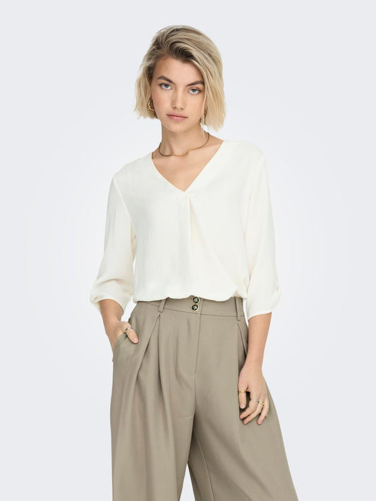 Blusa con escote en pico y manga francesa recogida con un botón. Tejido suave que no necesita plancha.  Composición: 100% Poliéster.  Se recomienda lavar a mano o en lavadora hasta 30º. No usar lejía, planchar suavemente del revés hasta 110º y no usar secadora.