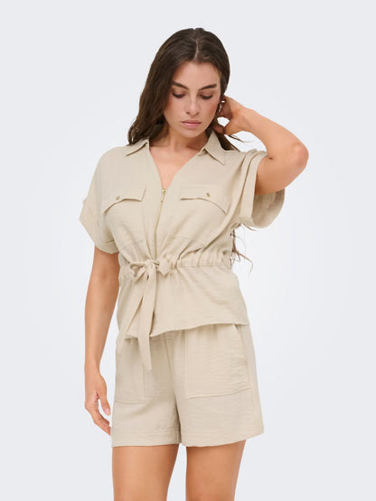 Sobrecamisa con cuello de camisa, manga corta, cinturón con lazo y cremallera.

Composición: 85% Viscosa y 15% Nylon.

Se recomienda lavar a mano o en lavadora hasta 30º. No usar lejía, planchar suavemente del revés hasta 110º y no usar secadora.