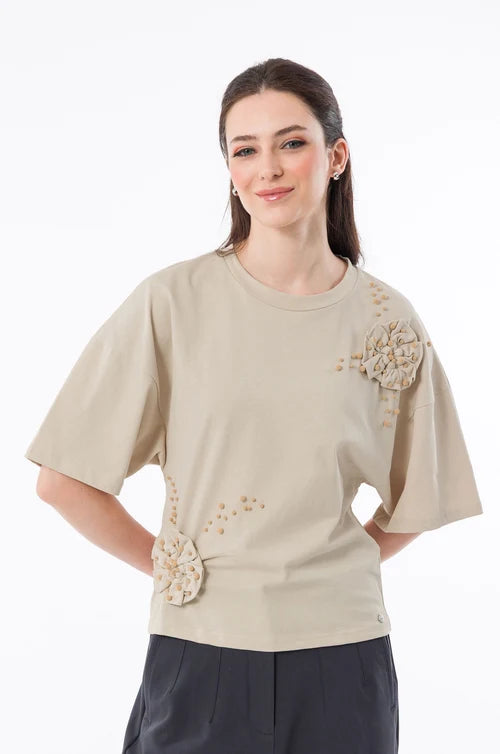 Camiseta de manga corta en tono beige con original aplicación floral en relieve y pequeños detalles decorativos. Su diseño combina sencillez y un toque artesanal que aporta personalidad. El tejido de algodón ofrece suavidad y comodidad para el día a día. Una prenda especial que añade un aire delicado y creativo a cualquier look.

Composición: !00% Algodón.

Se recomienda lavar a mano o en lavadora hasta 30º. No usar lejía, planchar suavemente del revés hasta 110º y no usar secadora.