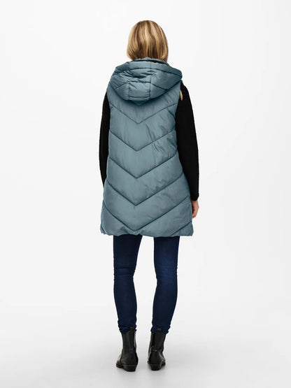 Chaleco largo con capucha.

Composición: 100% Poliéster.

Se recomienda lavar a mano o en lavadora hasta 30º. No usar lejía, planchar suavemente del revés hasta 110º y no usar secadora.